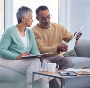 Finance, documents and senior couple on sofa with bills, paperwork and insurance checklist in home, life or asset management, Elderly black people on couch with financial, retirement or mortgage debt